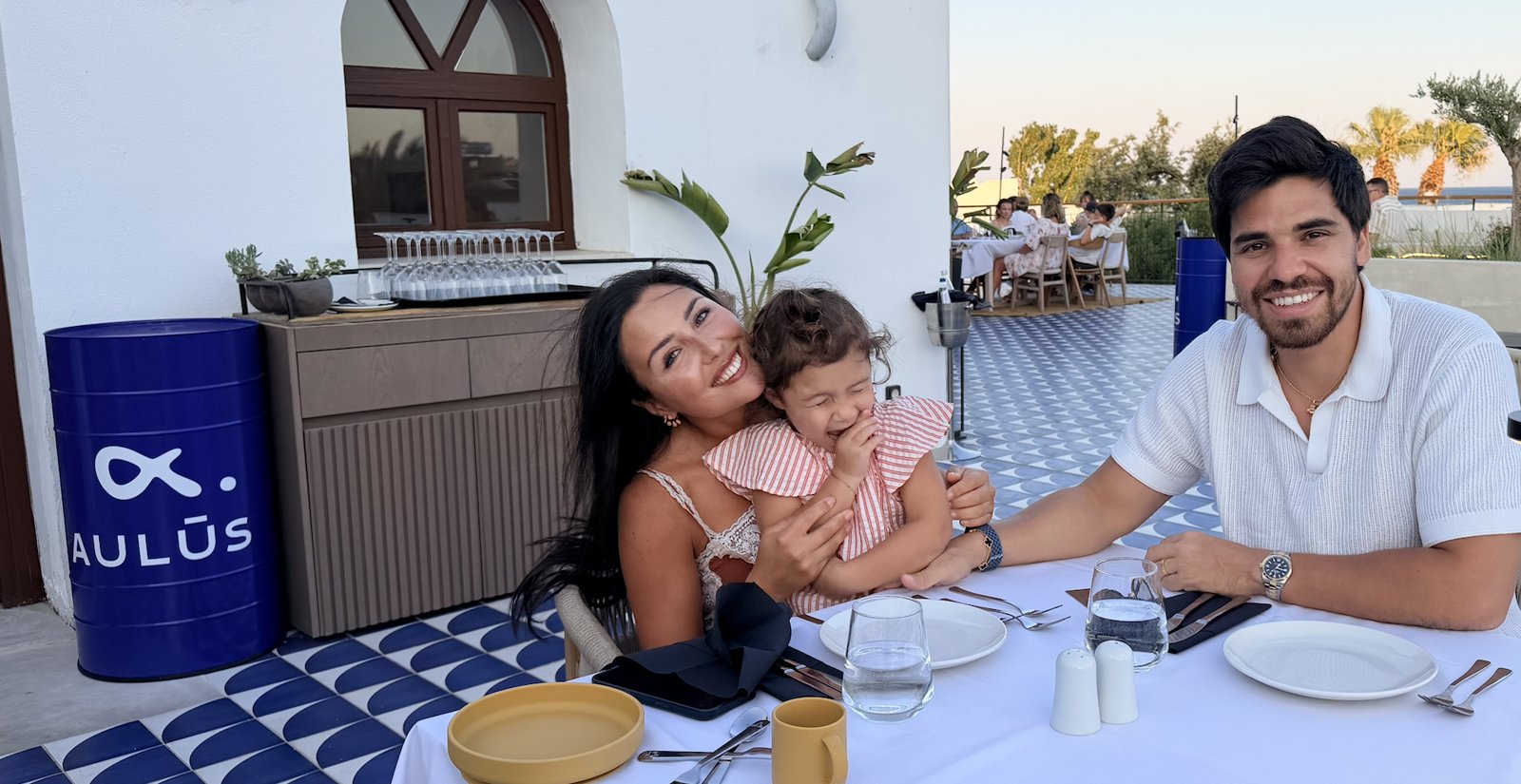 KidCall founder Yvan Alix Levy smiling at dinner with his family and young daughter in Rhodes, Greece